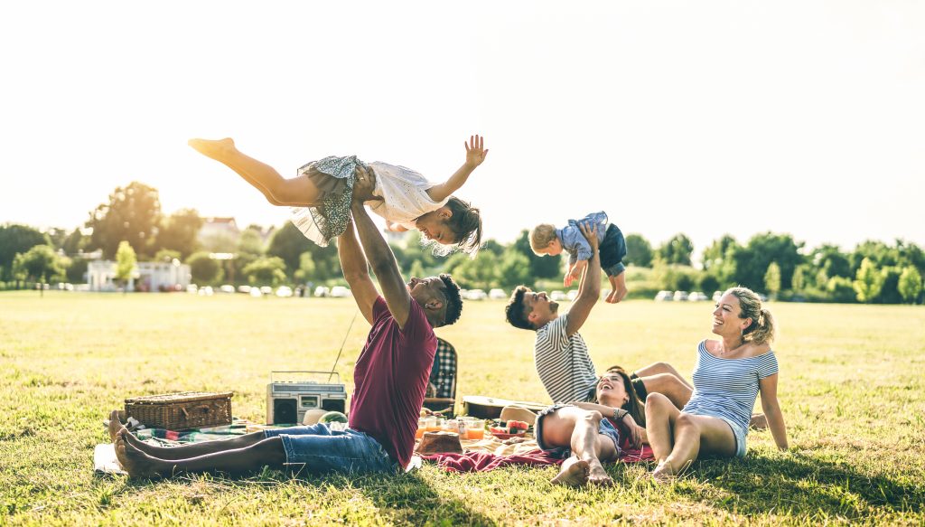Young multiracial families having fun playing with kids at pic nic barbecue party - Multicultural joy and love concept with mixed race people together with children at park - Warm contrasted filter Young multiracial families having fun playing with kids at pic nic barbecue party - Multicultural joy and love concept with mixed race people together with children at park - Warm contrasted filter