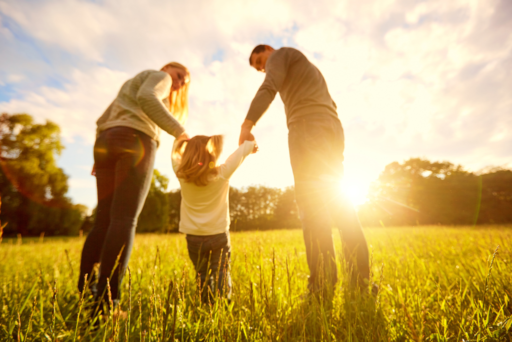 Parents with their child in a sunny field